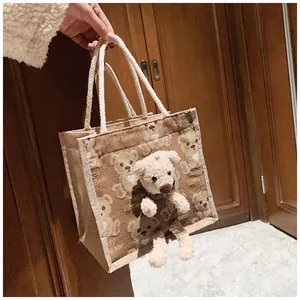 Close-up of jute canvas bag with 3D plush bear ornament and rope woven handle
