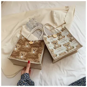 Detail of linen tote bags with bear prints, wooden buttons and hemp rope handles