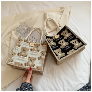 Detail of linen mini tote bags with cute bear prints and cotton rope handles