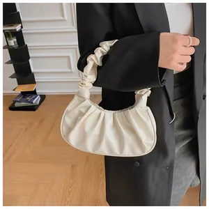 Close-up of creamy white pleated cloud bag showing soft PU leather texture and handle