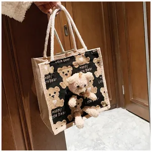 Detail of jute canvas tote bag with 3D plush bear ornament and cotton rope handles