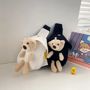 Dettaglio dell'orso di peluche sulla borsa a tracolla in tela con cerniera a contrasto