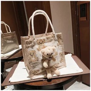 Close-up of bear print linen tote with a 3D plush teddy bear on a vintage wood table