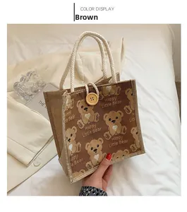 Detail of a brown linen bear tote bag featuring thick cotton rope handles and a wooden button