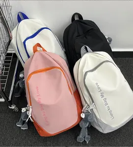 Close-up of stylish nylon backpacks in four colors featuring plush frog charms and letter print