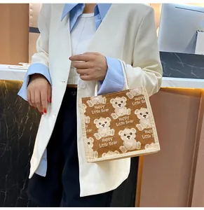 Detail of linen tote bag with cartoon bear pattern and Happy Little Bear text print