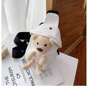 White canvas chest bag with cute plush bear and black wide strap on minimalist background