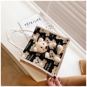 Detail of canvas lunch bag featuring cute 3D plush bear and woven rope handles