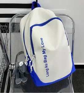 Detail of white and blue backpack with letter print and cute frog plush pendant accessory
