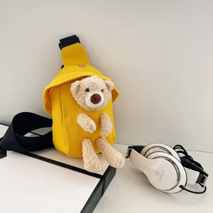 Dettaglio borsa a tracolla in tela gialla con simpatico orsetto di peluche 3D e fibbia
