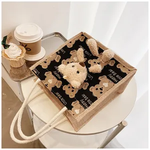 Detail of cute bear canvas tote bag with linen texture on a table with coffee