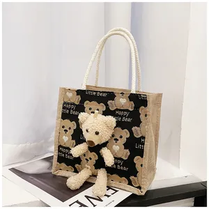 Detail view of canvas lunch bag featuring cute bear print and white rope handles