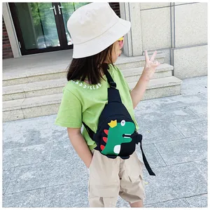 Nahaufnahme eines Kindes mit einer schwarzen Dinosaurier-Brusttasche und Schultergurt