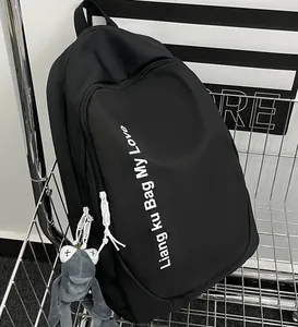Detail of black nylon backpack with letter print and gray frog plush charm in cart