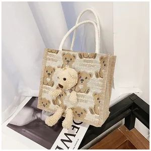 Detailed close-up of the canvas lunch bag with a 3D plush bear and woven rope handles