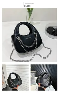 Detail of black vintage texture PU leather tote with dual silver chain and metal strap