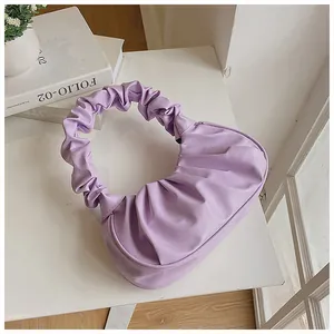 Detalle de un bolso nube plisado violeta claro que muestra su forma de medialuna y textura