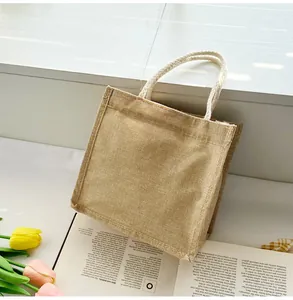 Detail of a square mini jute tote bag with white braided handles on a minimalist background