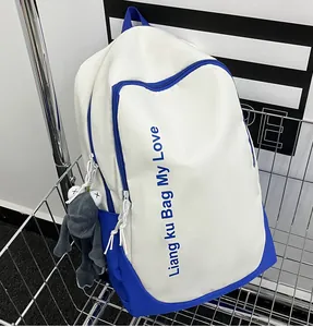 Detail of blue and beige backpack with letter print and grey frog pendant in a cart