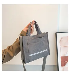 Detail of gray corduroy tote bag featuring soft texture and functional front outer pocket