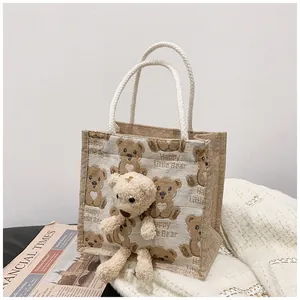 Detailed close-up of a jute lunch bag featuring 3D plush bear and cotton rope handles