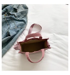 Detail view of pink corduroy tote bag showing interior lining and magnetic metal closure