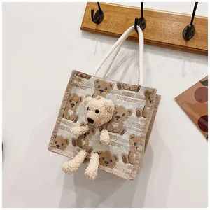 Close-up of canvas lunch bag featuring 3D plush bear and Happy Little Bear print