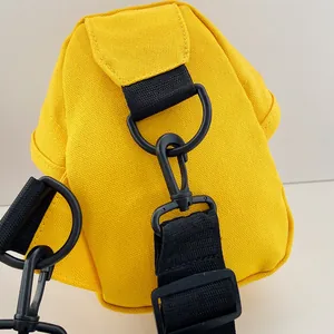 Dettaglio borsa in tela gialla con anello a D in metallo nero e chiusura a moschettone