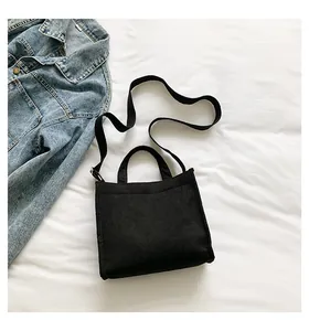 Detail view of durable black corduroy tote bag showing woven strap and fabric texture