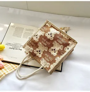 Detail of linen bear tote bag featuring woven rope handles and a cute cartoon print