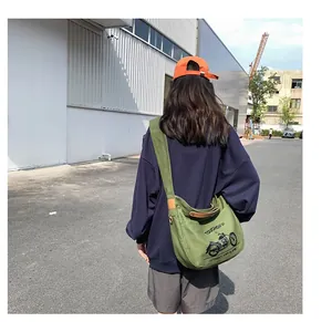 Olive green canvas crossbody bag with motorcycle print and wide strap detail