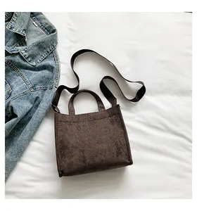Detail of dark brown corduroy tote bag showing ribbed texture and adjustable strap
