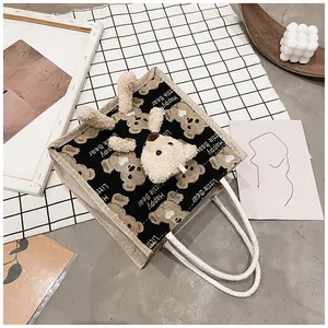 Detail of canvas lunch bag featuring 3D plush bear and Happy Little Bear print