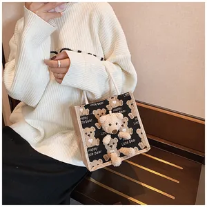 Close-up of cute canvas lunch bag featuring 3D teddy bear plush and black bear patterns