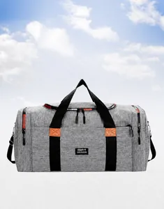 Detail of grey fabric travel bag featuring reinforced handles and branded logo patch