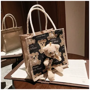 Close-up of beige canvas lunch bag featuring a 3D plush bear and Happy Little Bear print