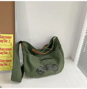 Detailed shot of army green canvas crossbody bag with vintage motorcycle print and leather strap