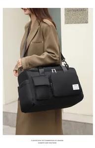 Detalle de bolsa de deporte negra impermeable con bolsillos laterales y bandolera