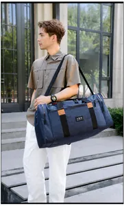 Blue waterproof travel bag with reinforced handles and adjustable strap detail view