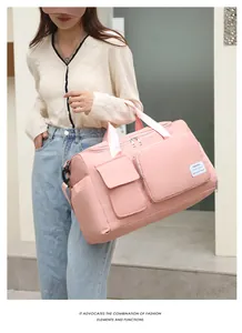 Detalle de la bolsa de deporte rosa con múltiples bolsillos con cremallera y asas de mano