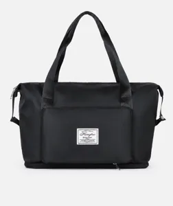 Detailed view of black waterproof travel bag with reinforced handles and front zipper pocket