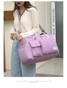 Detalle de bolsa de viaje morada en tejido impermeable con prácticos bolsillos frontales