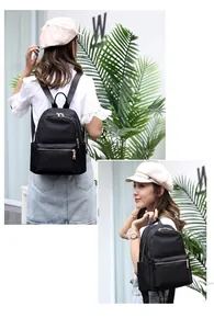 Detail view of black nylon backpack featuring golden metal zippers and side pockets