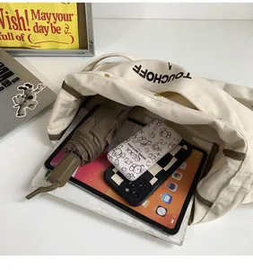 Detailed internal view of beige canvas shoulder bag showing large capacity for tablet and items