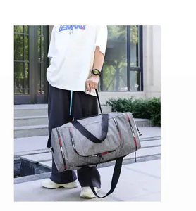 Detail view of large grey waterproof travel bag with woven fashion straps and durable handles