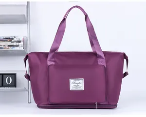 Detail of expandable purple travel bag with suitcase handle sleeve and logo label