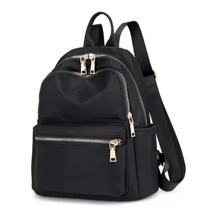 Minimalist black nylon backpack for women featuring stylish gold zippers and multi-pockets