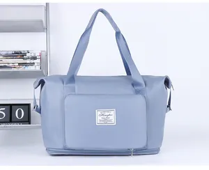 Detail view of fog blue travel bag showing the waterproof nylon texture and brand label