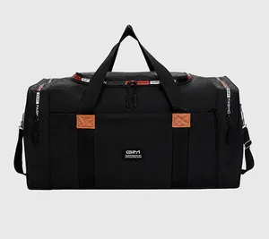 Detail view of large black waterproof nylon travel bag with brown leather accents and straps
