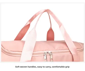 Close-up of the soft pink woven handles and dual zipper closure on a fitness duffel bag